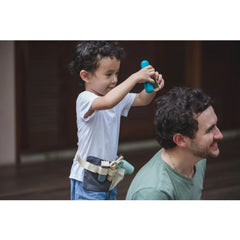 boy cutting dad's hair with plan toys hair dresser set